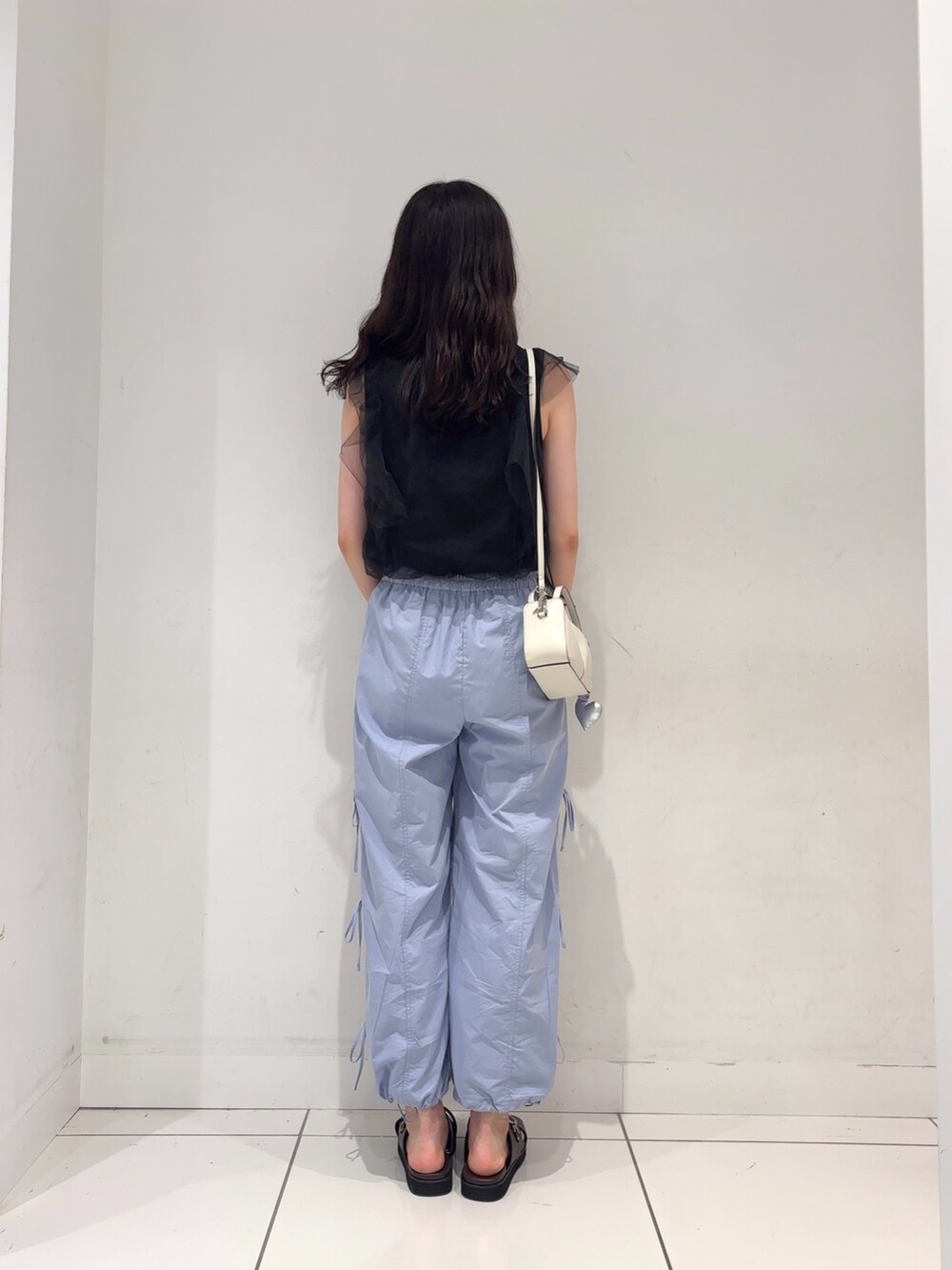 ブラック系のその他トップス、ブラウン系のサンダル、ブルー系のその他パンツを着用したレディースの夏コーディネートの2枚目の写真