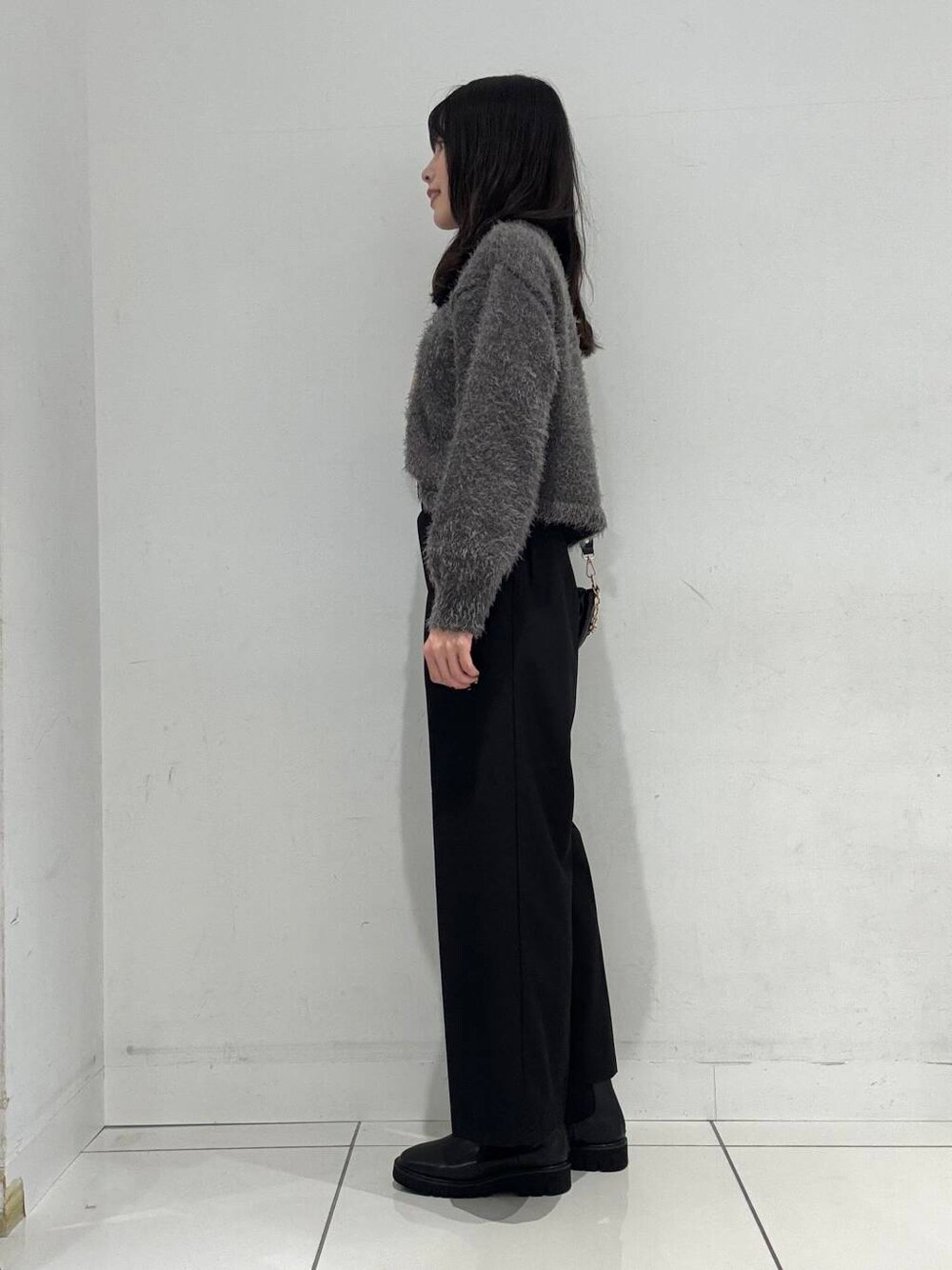 ブラック系のその他パンツ、ブラック系のブーツ、ブラック系のショルダーバッグを着用したレディースの冬コーディネートの2枚目の写真