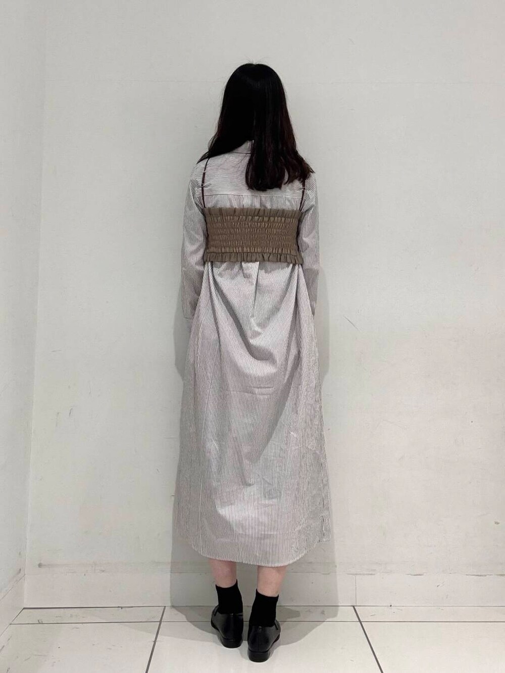 ブルー系のハンドバッグ、ブラック系のローファー、ベージュ系のワンピースを着用したレディースの春コーディネートの3枚目の写真