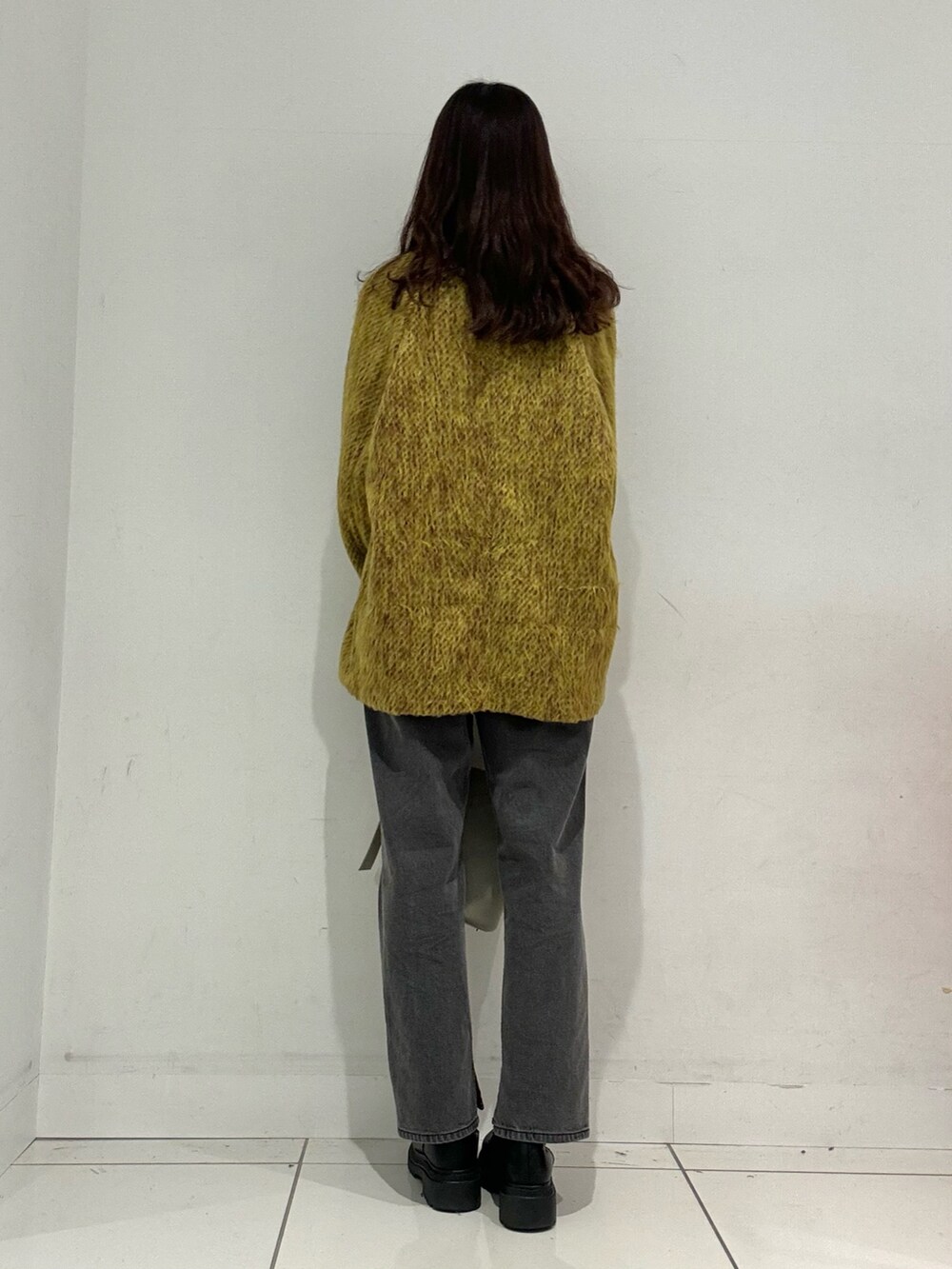 イエロー系のステンカラーコート、グレー系のその他パンツ、ベージュ系のハンドバッグを着用したレディースの秋コーディネートの3枚目の写真