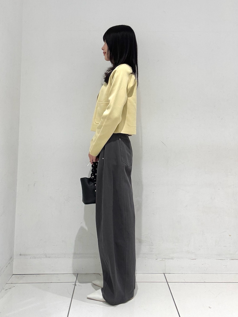 ベージュ系のカーディガン/ボレロ、ホワイト系のキャミソール、グレー系のその他パンツを着用したレディースの春コーディネートの2枚目の写真