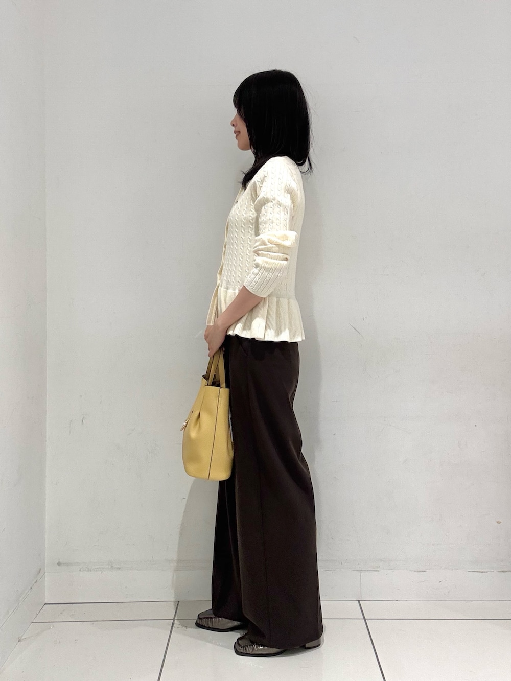 ホワイト系のニット/セーター、ブラウン系のその他パンツ、ホワイト系のトートバッグを着用したレディースの秋コーディネートの2枚目の写真
