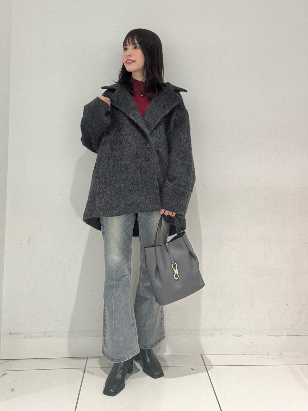 グレー系のその他アウター、レッド系のニット/セーター、ブルー系のその他パンツを着用したレディースの秋コーディネートの4枚目の写真