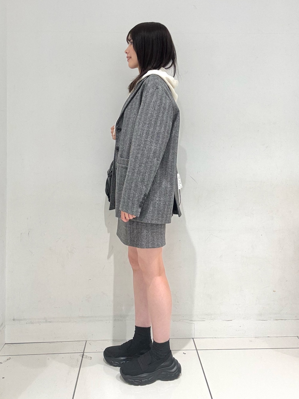 ブラック系のローファー、ホワイト系のニット/セーター、ブラック系のその他アウターを着用したレディースの秋コーディネートの2枚目の写真