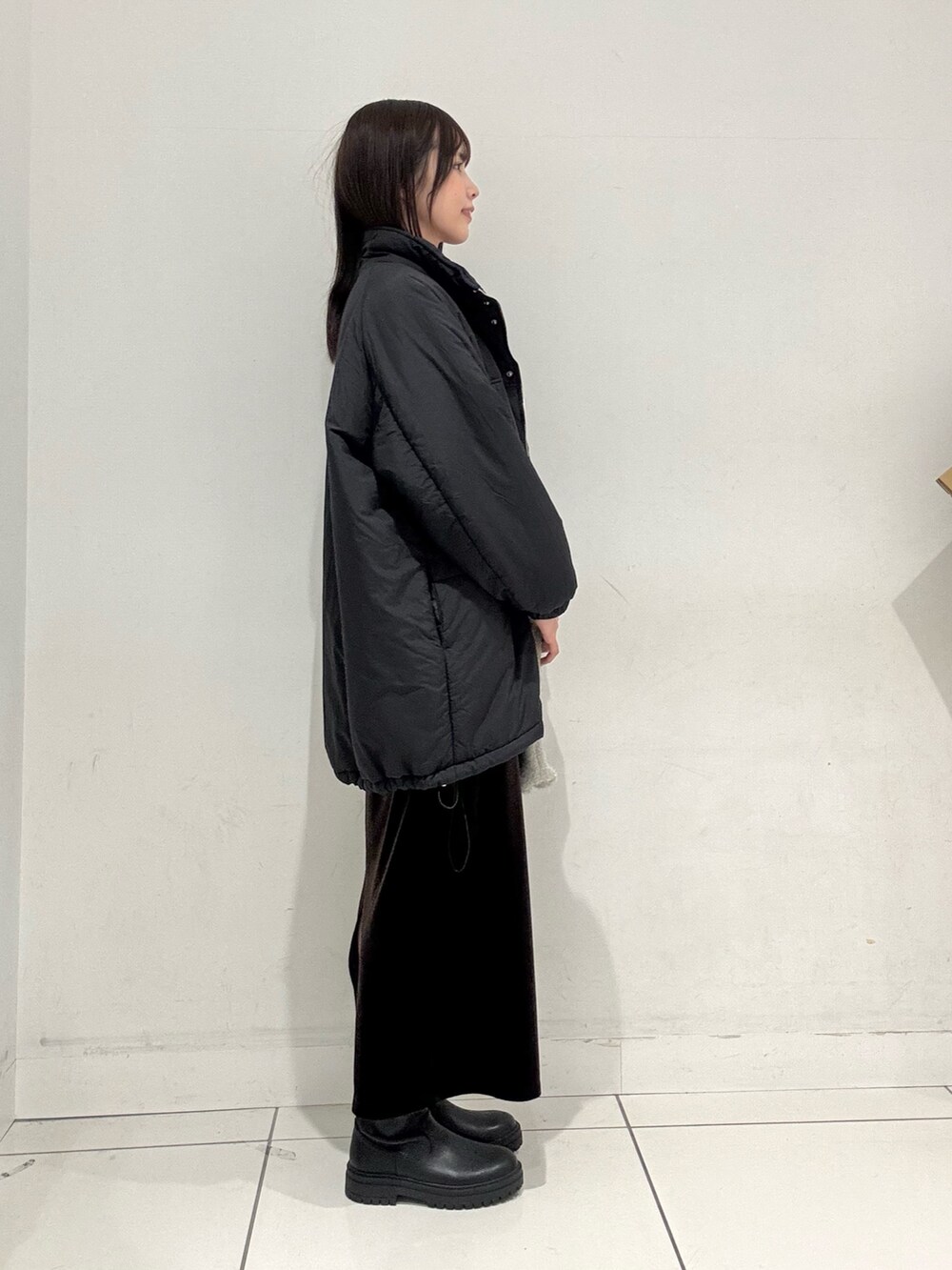 ブルー系のカーディガン/ボレロ、ブラック系のダウンジャケット/コート、ブラウン系のスカートを着用したレディースの冬コーディネートの2枚目の写真