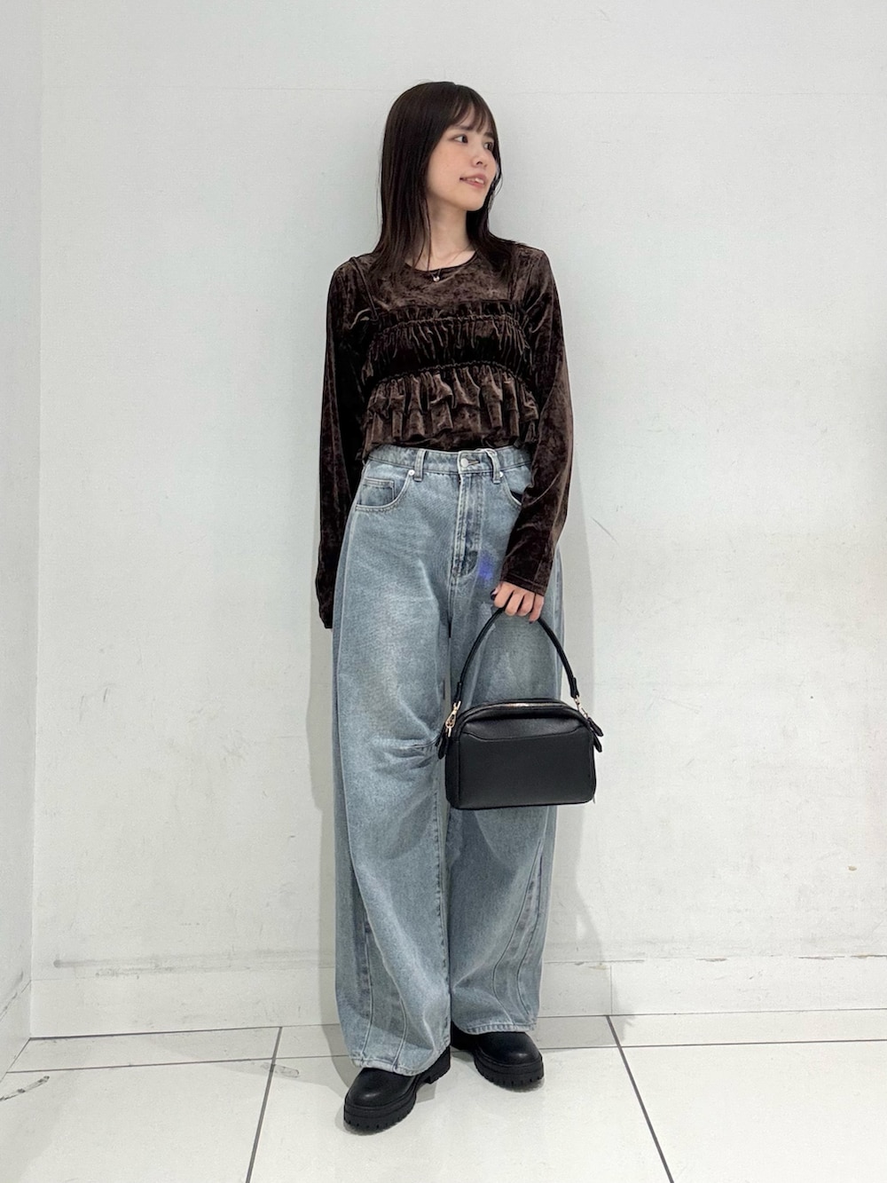 ブラウン系のTシャツ/カットソー、ブルー系のデニムパンツ、ブラック系のショルダーバッグを着用したレディースの冬コーディネートの4枚目の写真