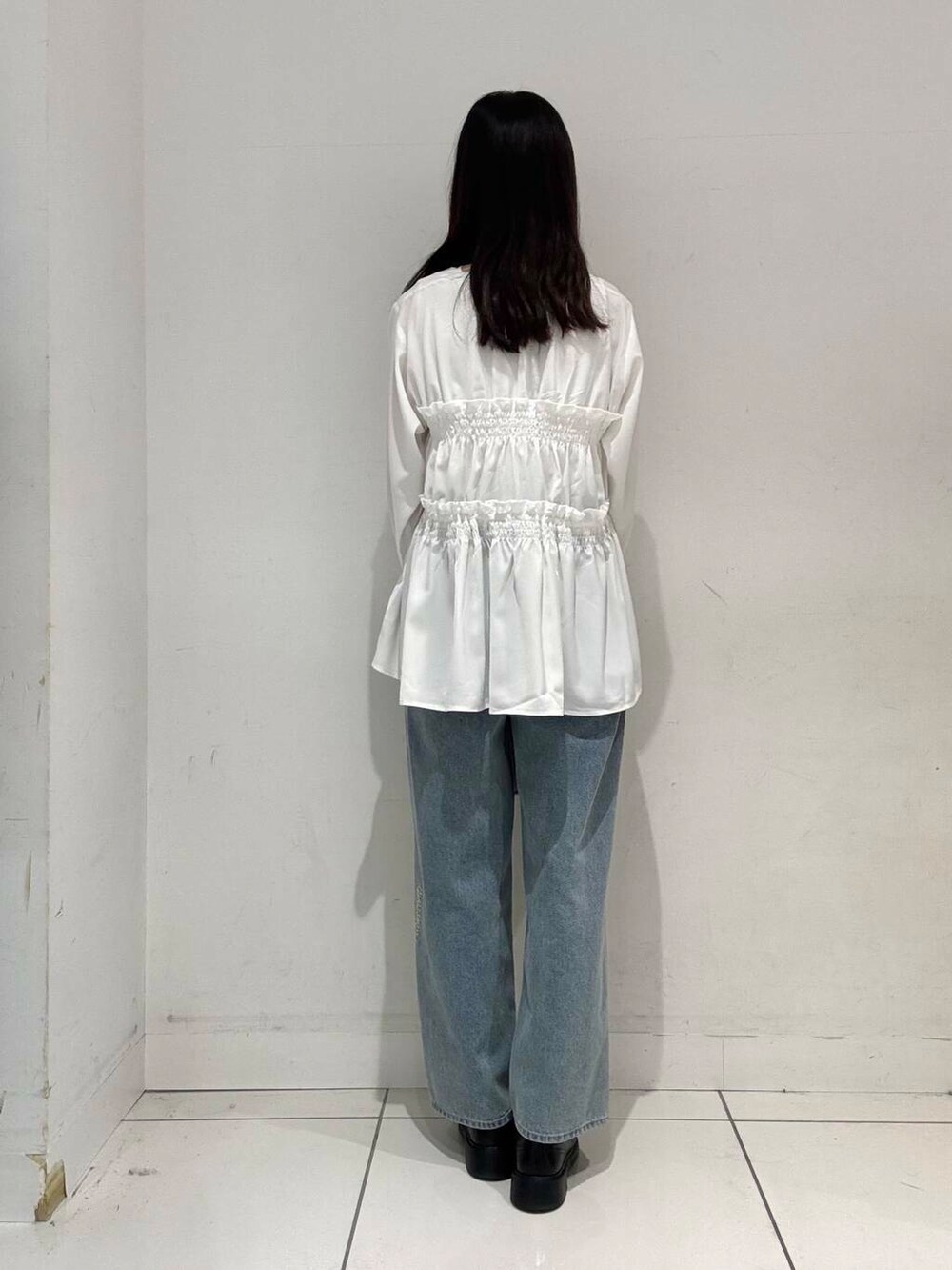 グリーン系のトートバッグ、ブルー系のデニムパンツ、ホワイト系のシャツ/ブラウスを着用したレディースの春コーディネートの3枚目の写真