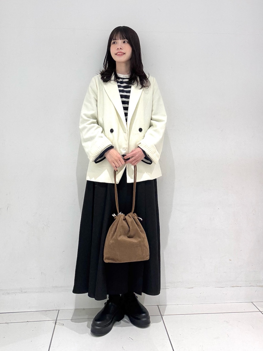 ブルー系のTシャツ/カットソー、ホワイト系のテーラードジャケット、ブラウン系のハンドバッグを着用したレディースの冬コーディネートの3枚目の写真