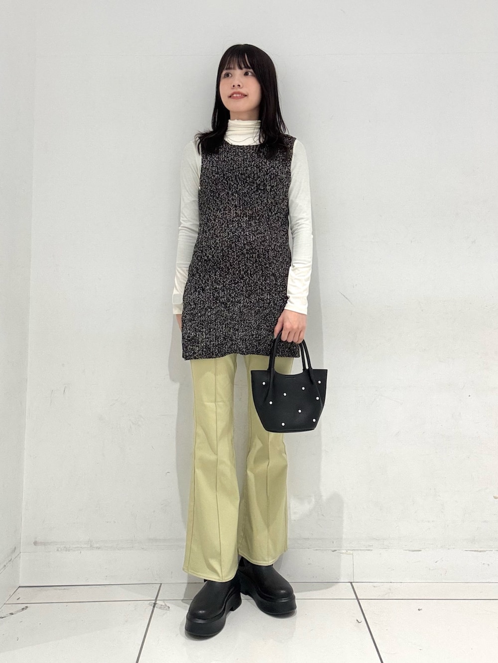 ホワイト系のTシャツ/カットソー、ブラック系のベスト、ブラック系のその他シューズを着用したレディースの冬コーディネートの4枚目の写真