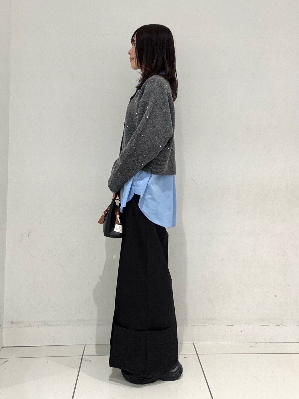 グレー系のカーディガン/ボレロ、ブルー系のシャツ/ブラウス、ブラック系のその他パンツを着用したレディースの秋コーディネートの2枚目の写真