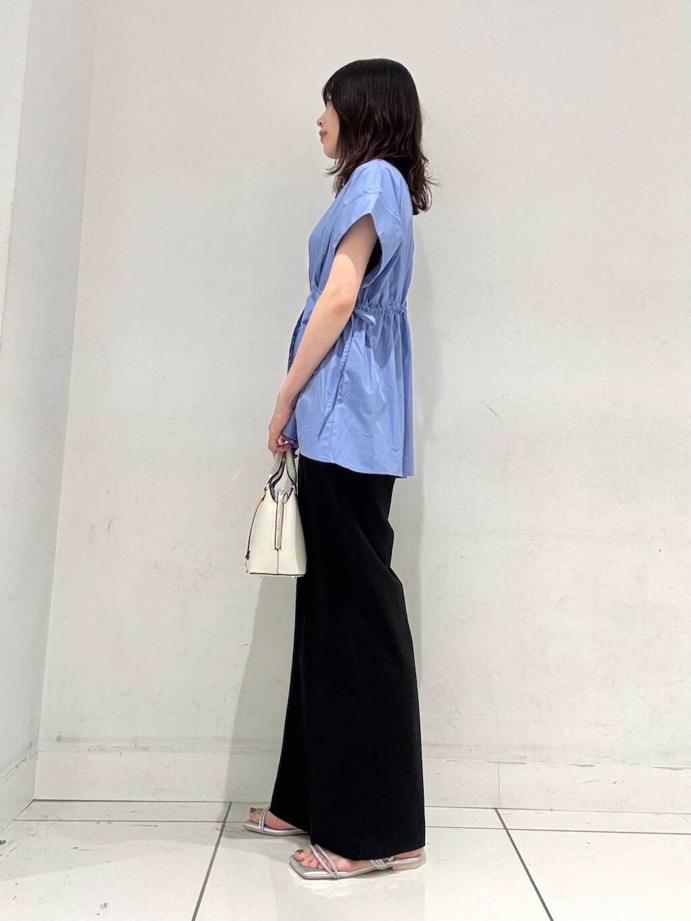 ホワイト系のハンドバッグ、ブラック系のその他パンツ、シルバー系のサンダルを着用したレディースの夏コーディネートの2枚目の写真
