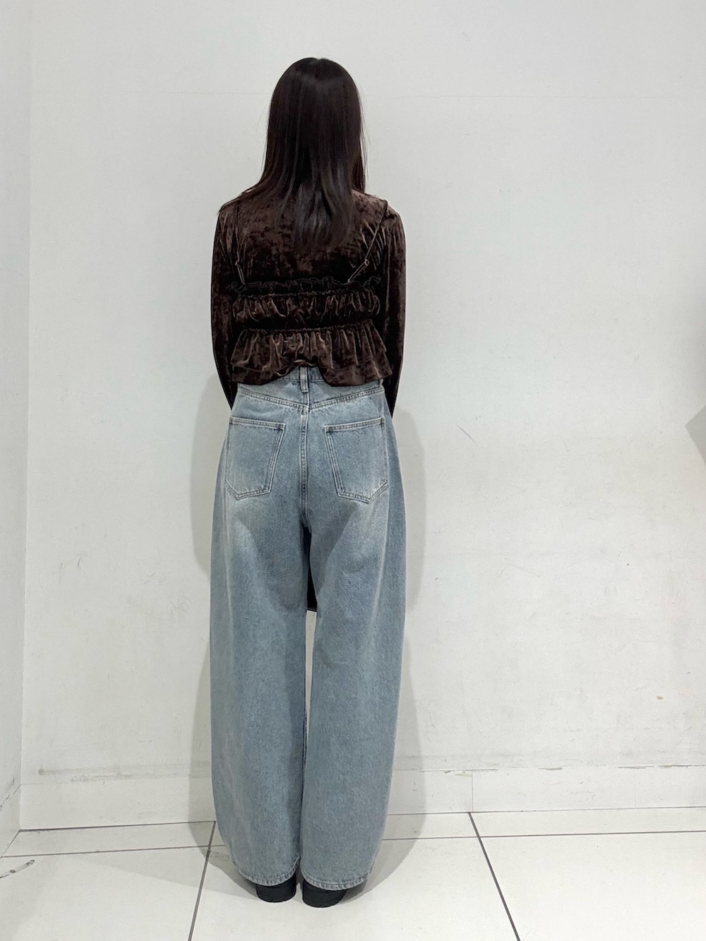 ブラウン系のTシャツ/カットソー、ブルー系のデニムパンツ、ブラック系のショルダーバッグを着用したレディースの冬コーディネートの3枚目の写真