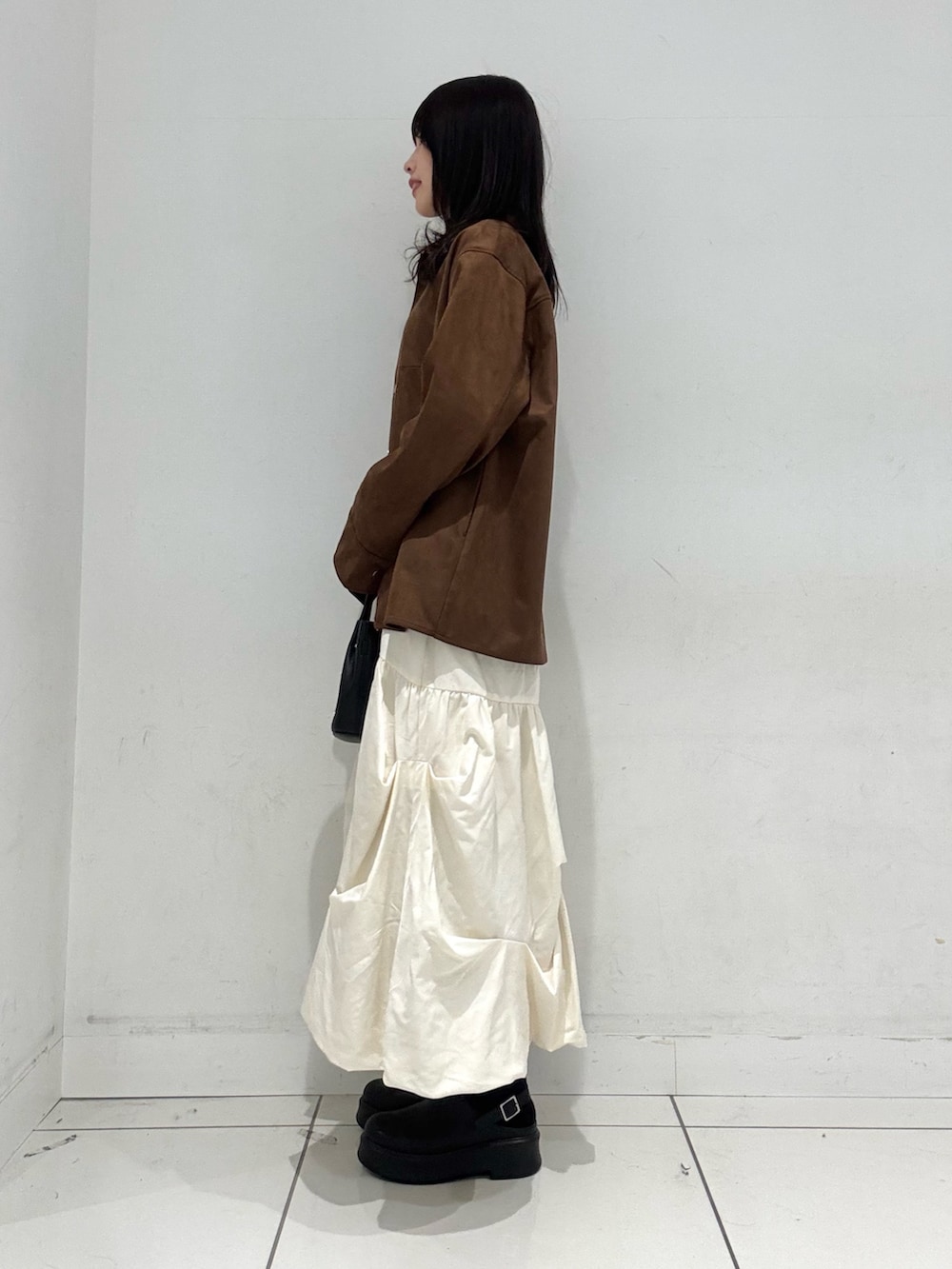 ホワイト系のスカート、ブラウン系のその他アウター、ホワイト系のニット/セーターを着用したレディースの冬コーディネートの2枚目の写真