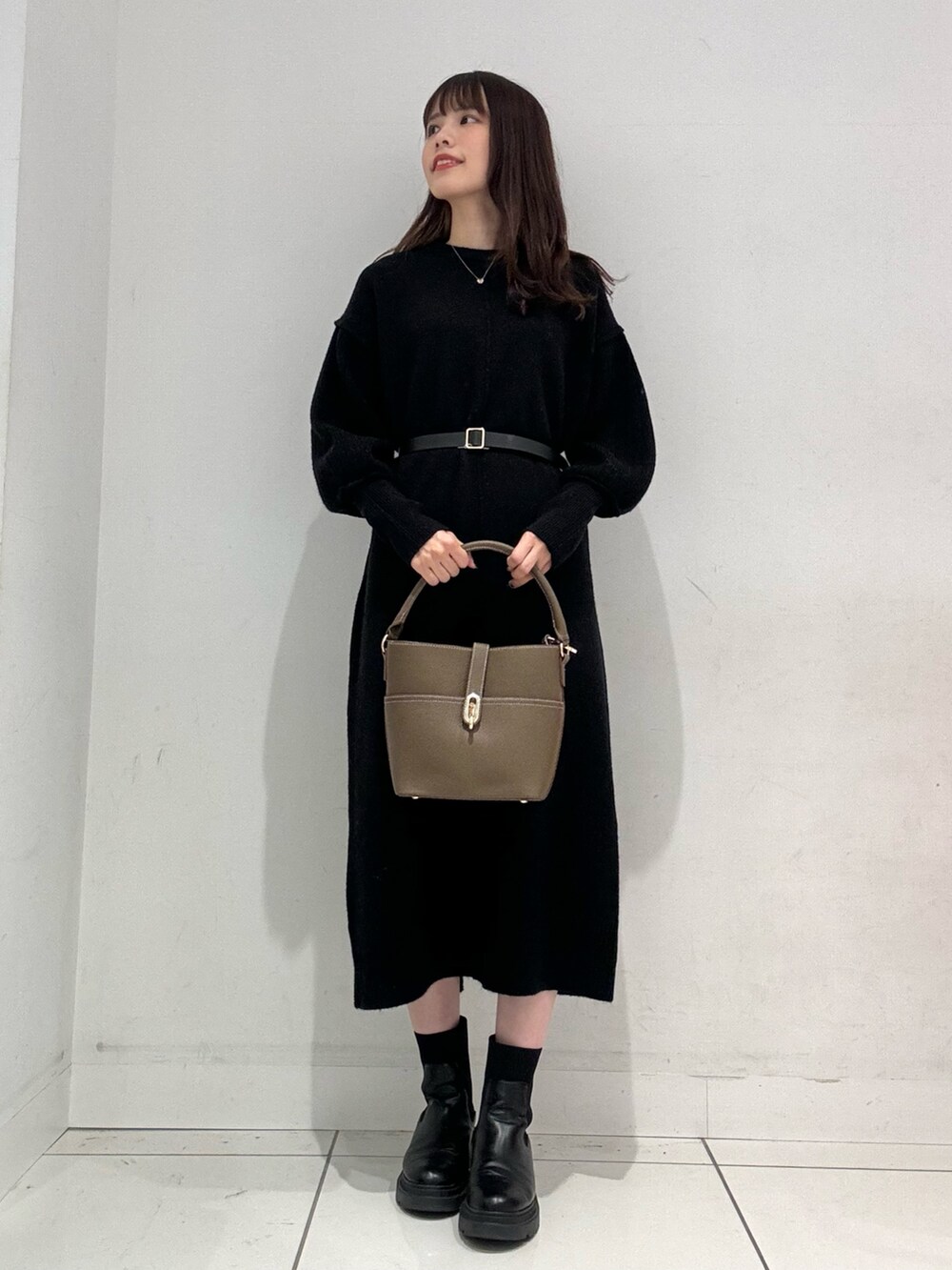 ブラック系のワンピース、ベージュ系のハンドバッグ、ベージュ系のその他アウターを着用したレディースの秋コーディネートの5枚目の写真