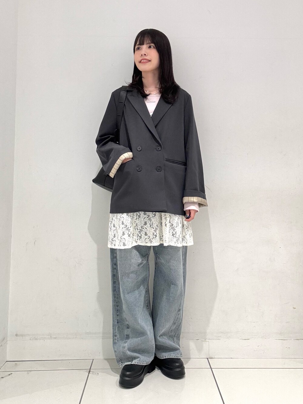 ホワイト系のキャミソール、ブルー系のデニムパンツ、ブラック系のその他シューズを着用したレディースの冬コーディネートの4枚目の写真