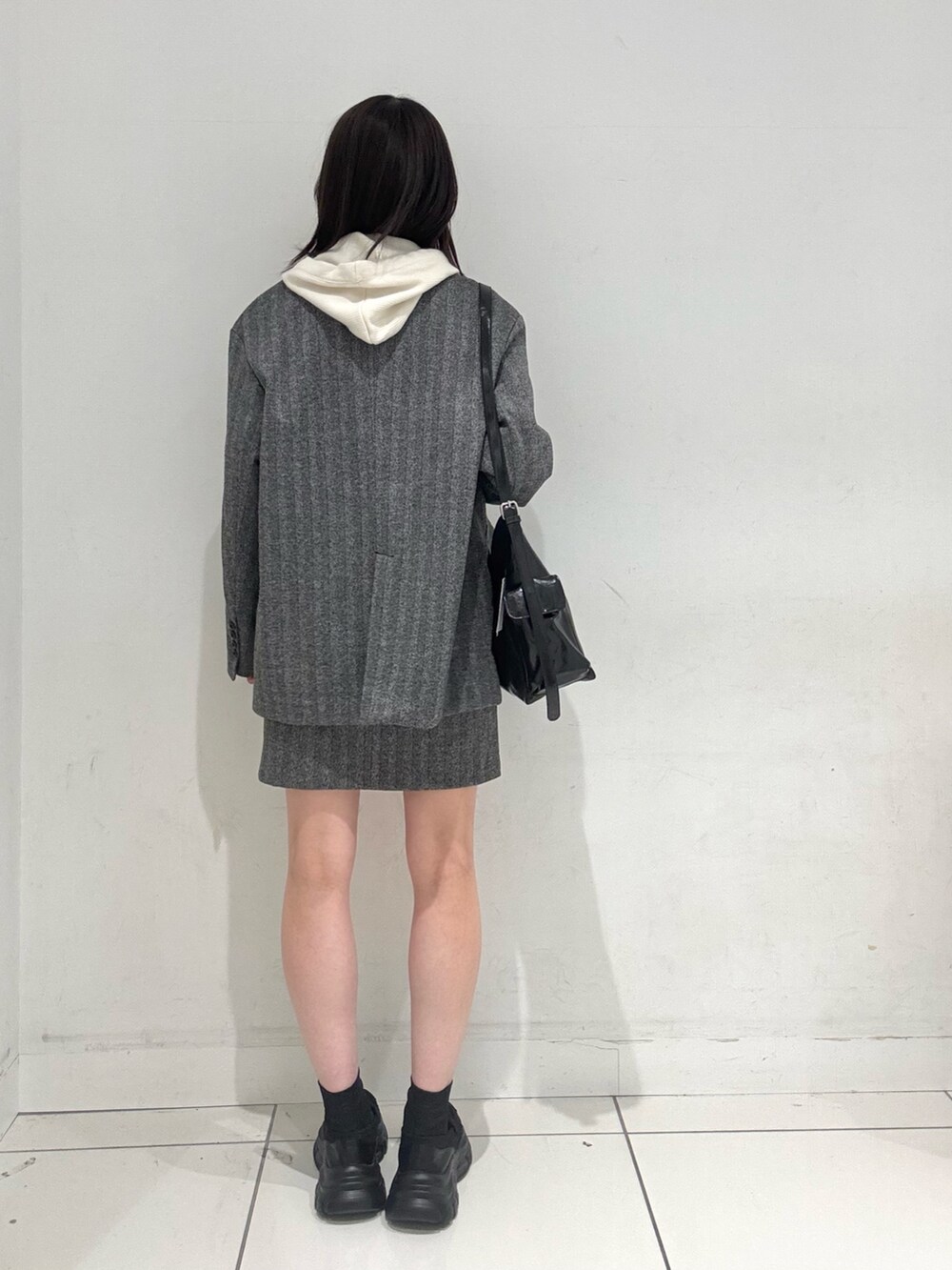 ブラック系のローファー、ホワイト系のニット/セーター、ブラック系のその他アウターを着用したレディースの秋コーディネートの3枚目の写真