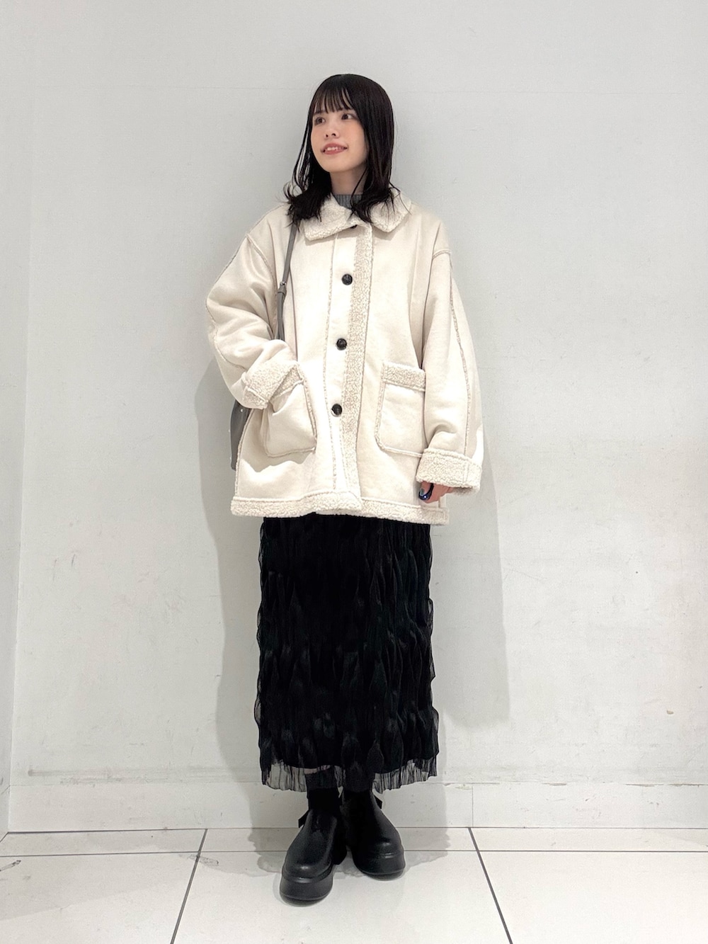 ブラック系のスカート、ブラック系のその他シューズ、グレー系のハンドバッグを着用したレディースの冬コーディネートの4枚目の写真