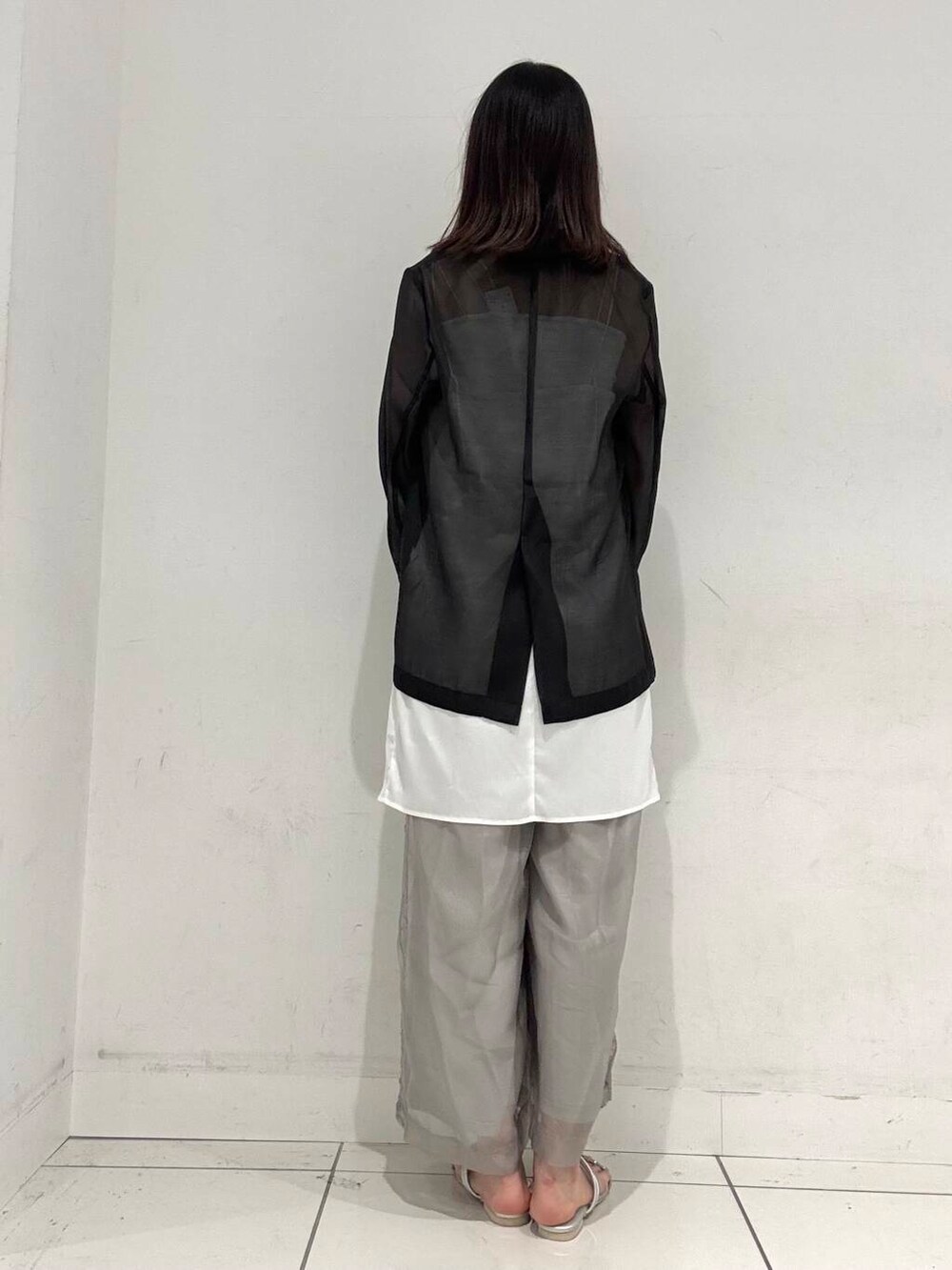 シルバー系のハンドバッグ、ホワイト系のタンクトップ、シルバー系のサンダルを着用したレディースの夏コーディネートの3枚目の写真