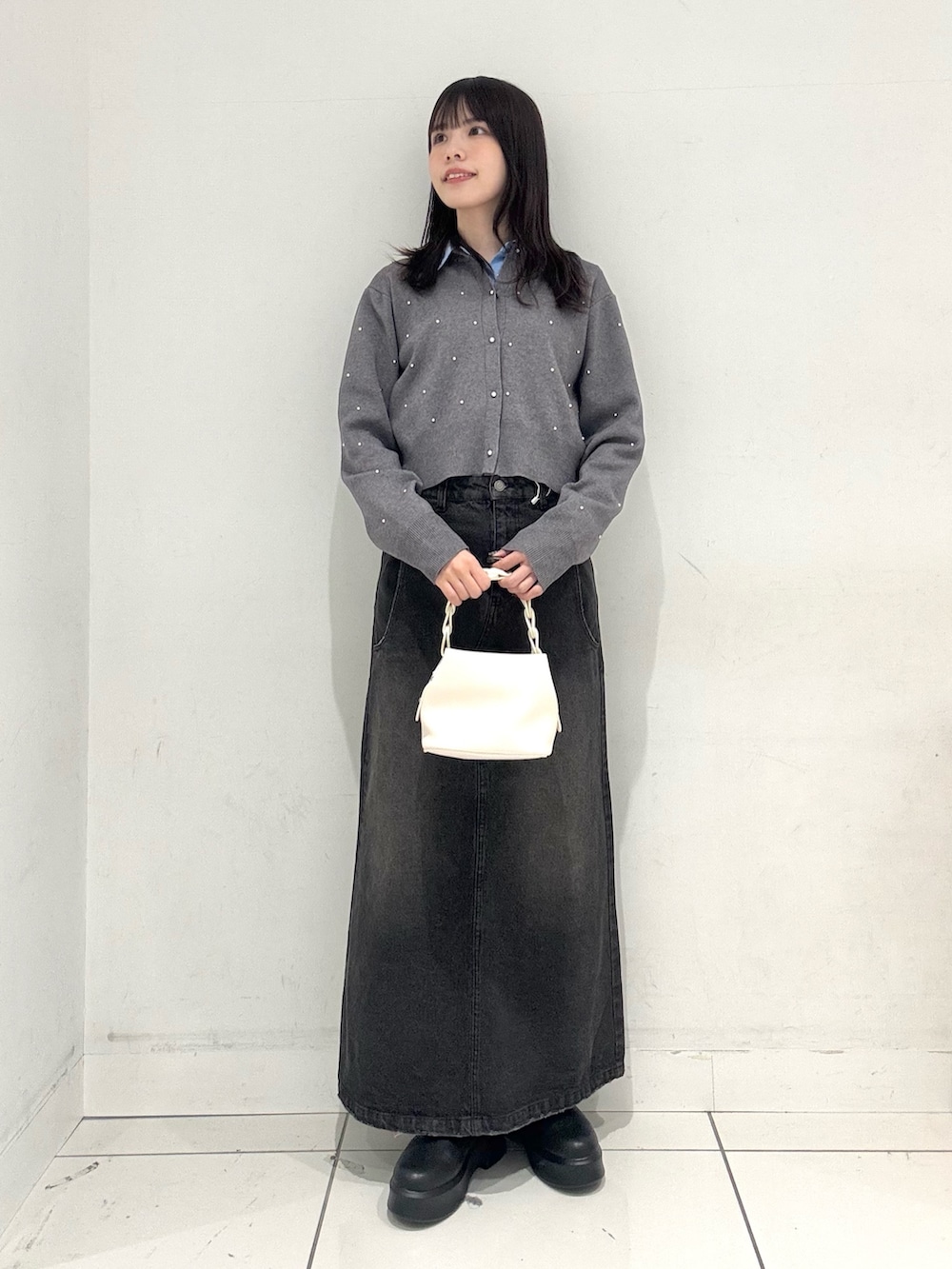 ブラック系のスカート、ブラック系のその他シューズ、ホワイト系のショルダーバッグを着用したレディースの冬コーディネートの4枚目の写真