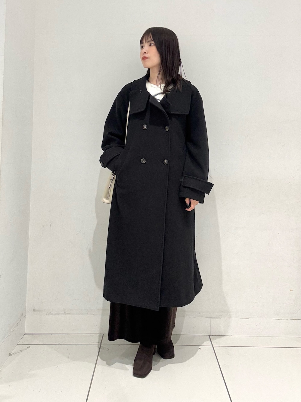 ホワイト系のニット/セーター、ブラウン系のスカート、ブラウン系のブーツを着用したレディースの秋コーディネートの3枚目の写真