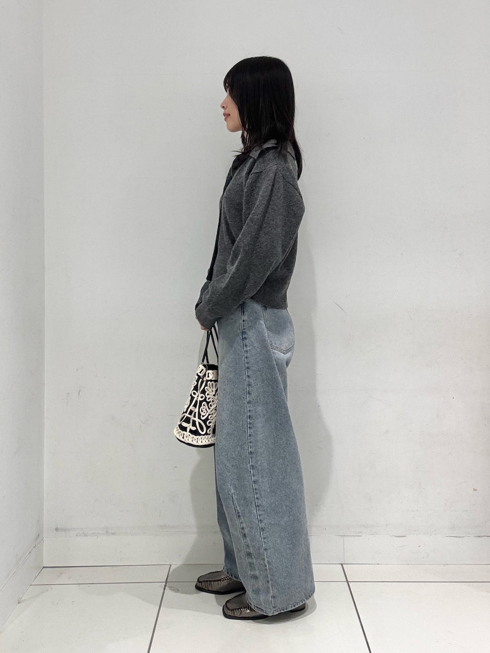 グレー系のニット/セーター、ホワイト系のニット/セーター、ブルー系のデニムパンツを着用したレディースの秋コーディネートの2枚目の写真