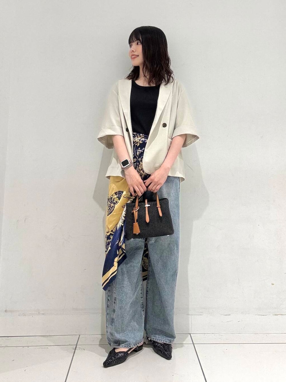 ブラック系のサンダル、ブラック系のトートバッグ、ブルー系のデニムパンツを着用したレディースの夏コーディネートの4枚目の写真