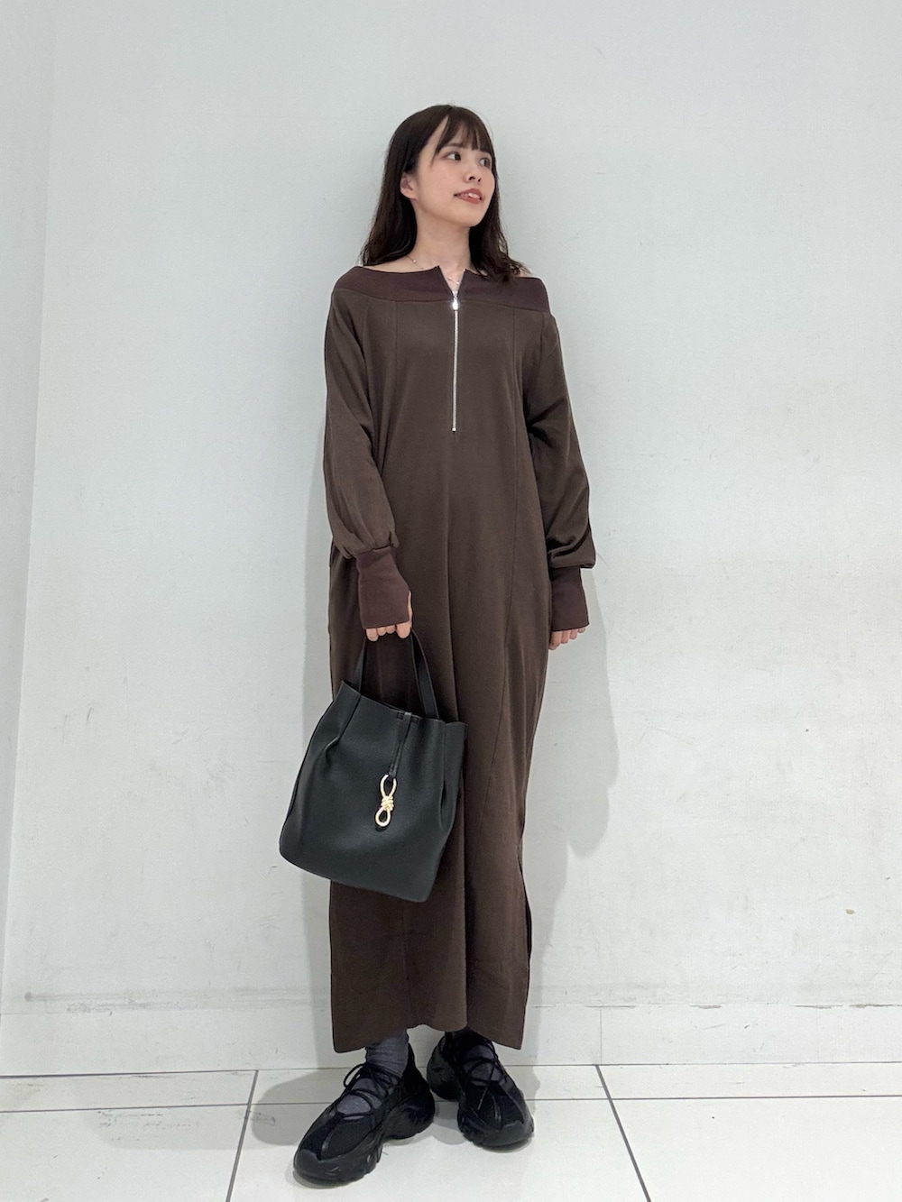 ブラウン系のワンピース、ブラック系のスニーカー、ブラック系のトートバッグを着用したレディースの秋コーディネートの4枚目の写真
