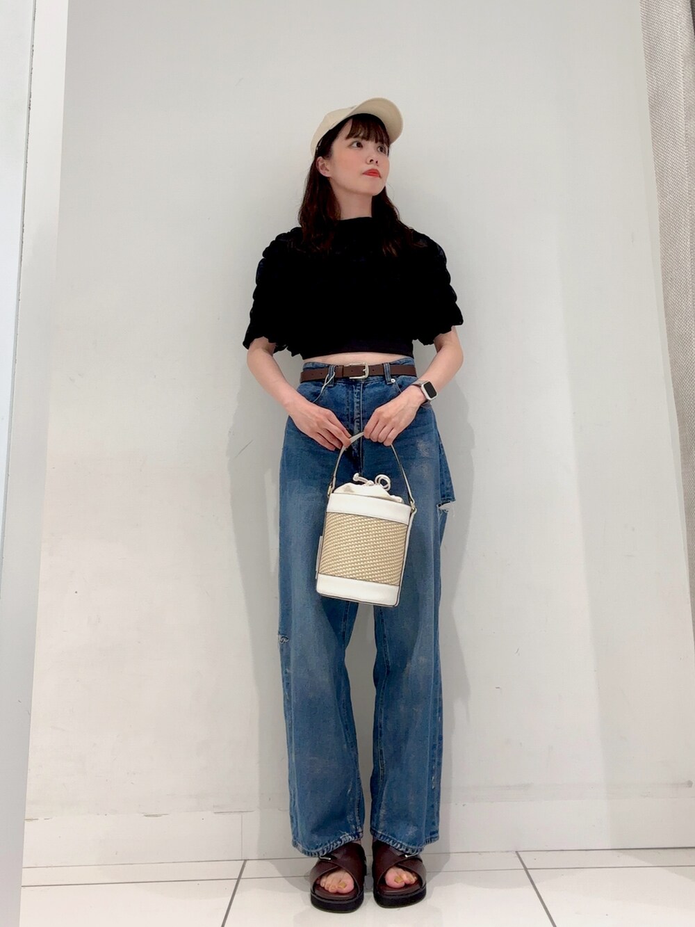 ブルー系のデニムパンツ、ブラック系のTシャツ/カットソー、ホワイト系のショルダーバッグを着用したレディースの夏コーディネートの3枚目の写真