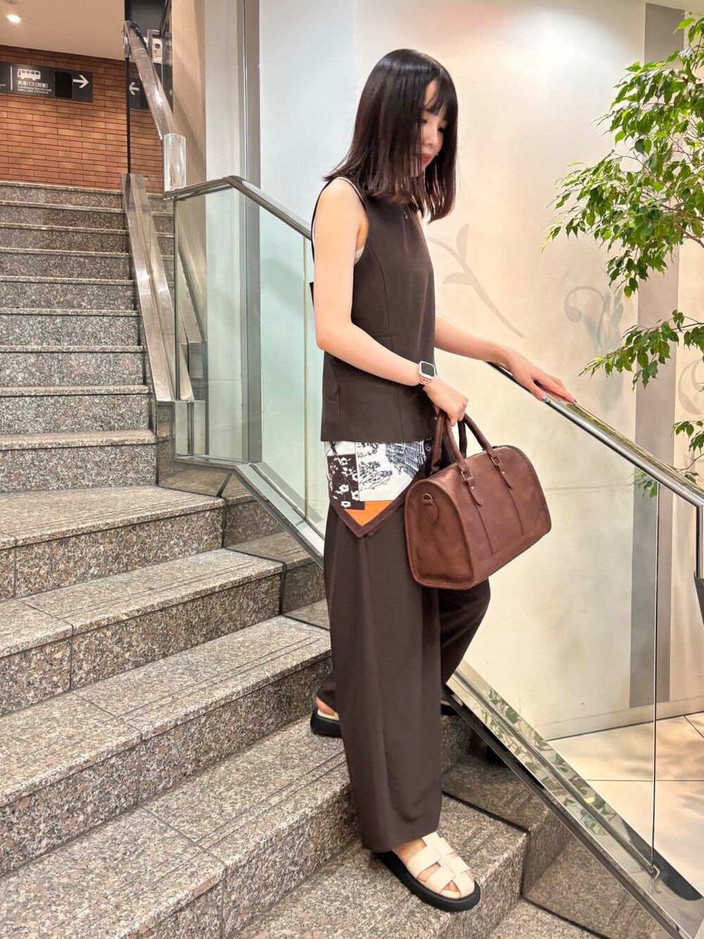 ブラウン系のボストンバッグ、ベージュ系のタンクトップ、ブラウン系のセットアップを着用したレディースの春コーディネートの2枚目の写真