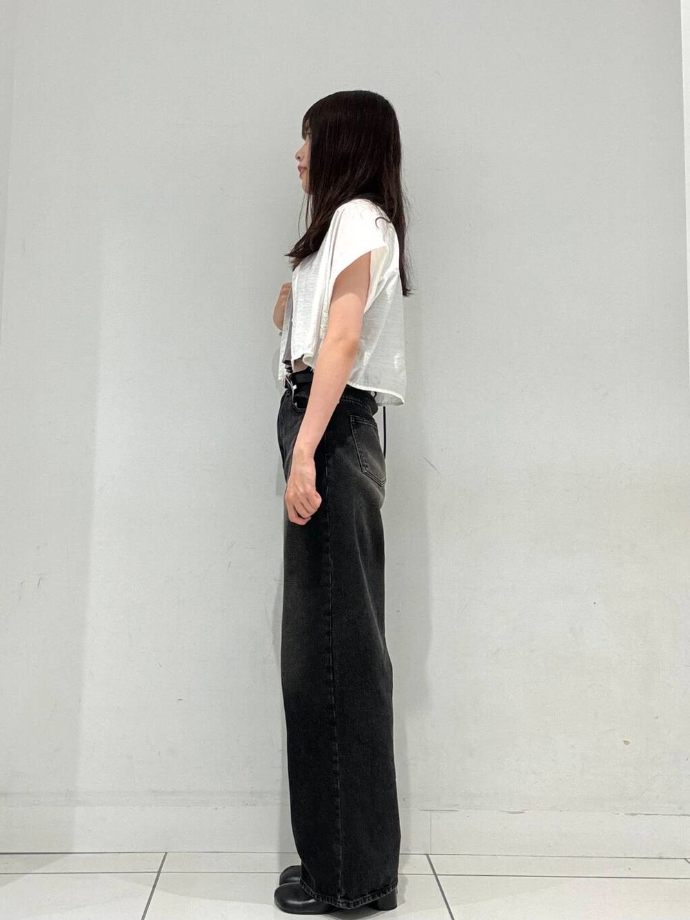 ブラック系のショルダーバッグ、ホワイト系のシャツ/ブラウス、ブラック系のサンダルを着用したレディースの秋コーディネートの3枚目の写真