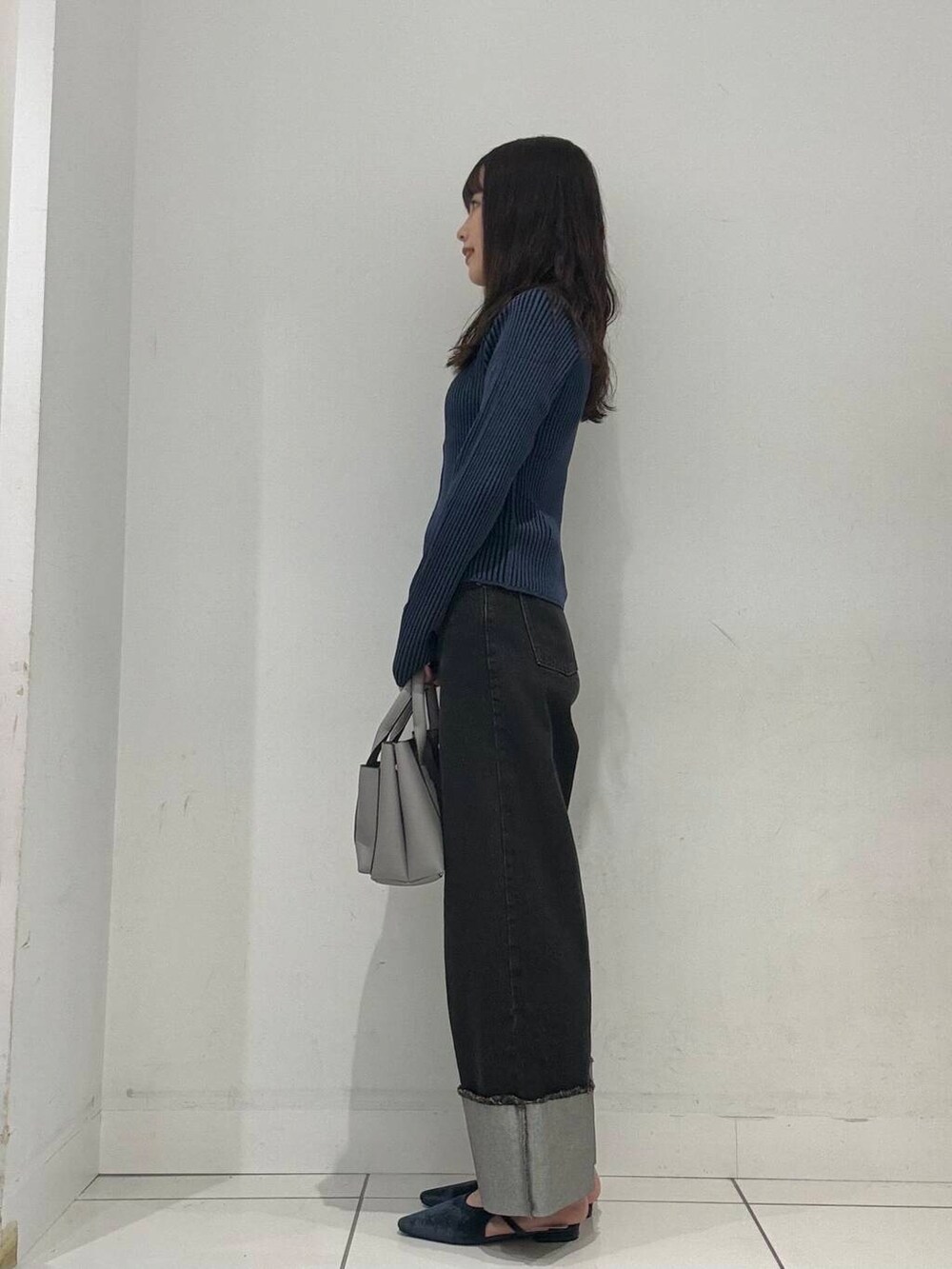 ブルー系のパンプス、グレー系のトートバッグ、ブルー系のニット/セーターを着用したレディースの夏コーディネートの3枚目の写真