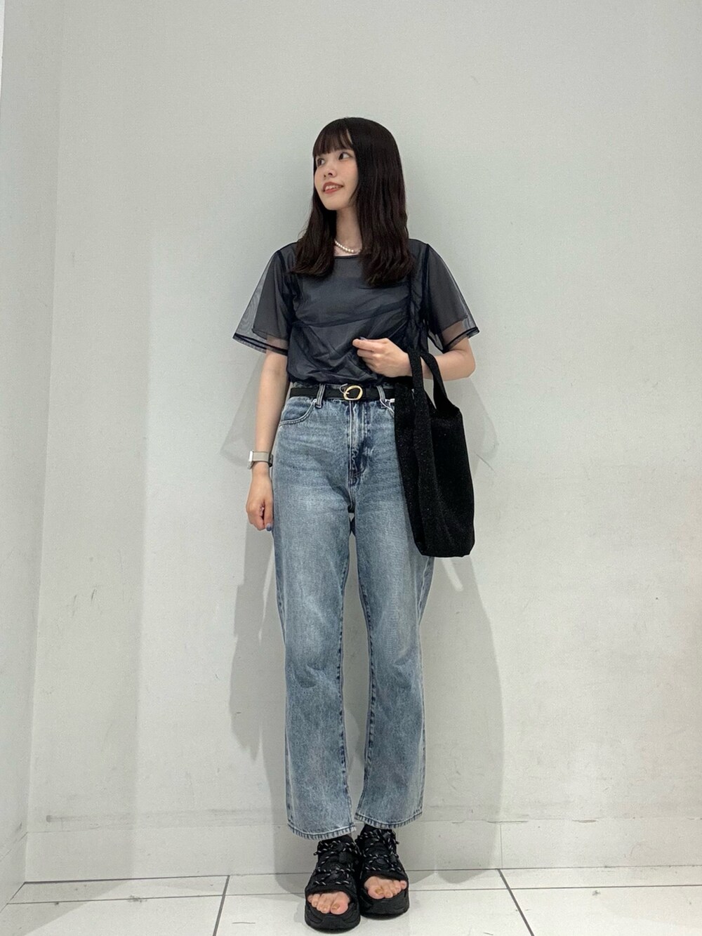 ブルー系のTシャツ/カットソー、ブルー系のデニムパンツ、ブラック系のトートバッグを着用したレディースの夏コーディネートの2枚目の写真