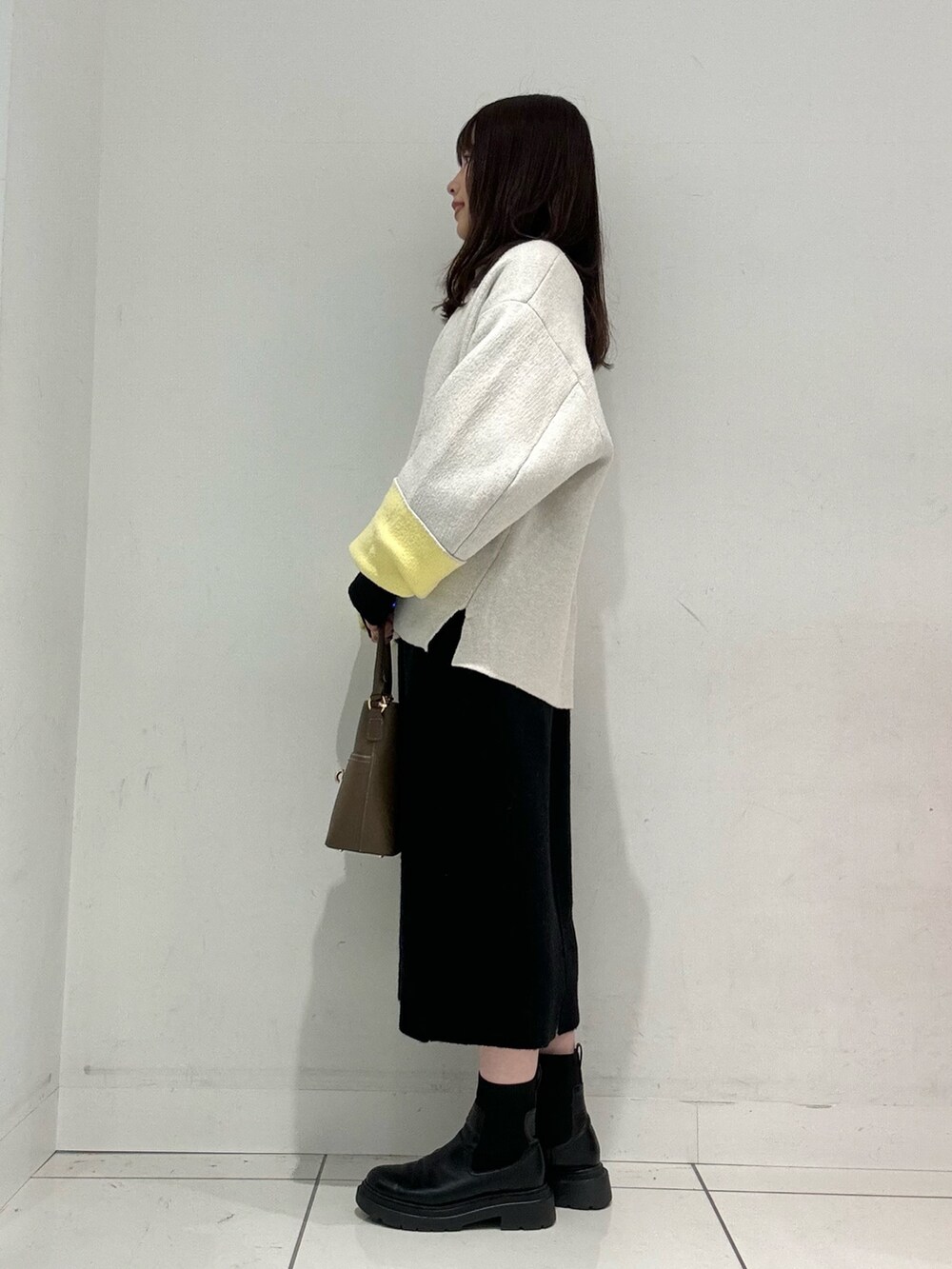 ブラック系のワンピース、ベージュ系のハンドバッグ、ベージュ系のその他アウターを着用したレディースの秋コーディネートの3枚目の写真