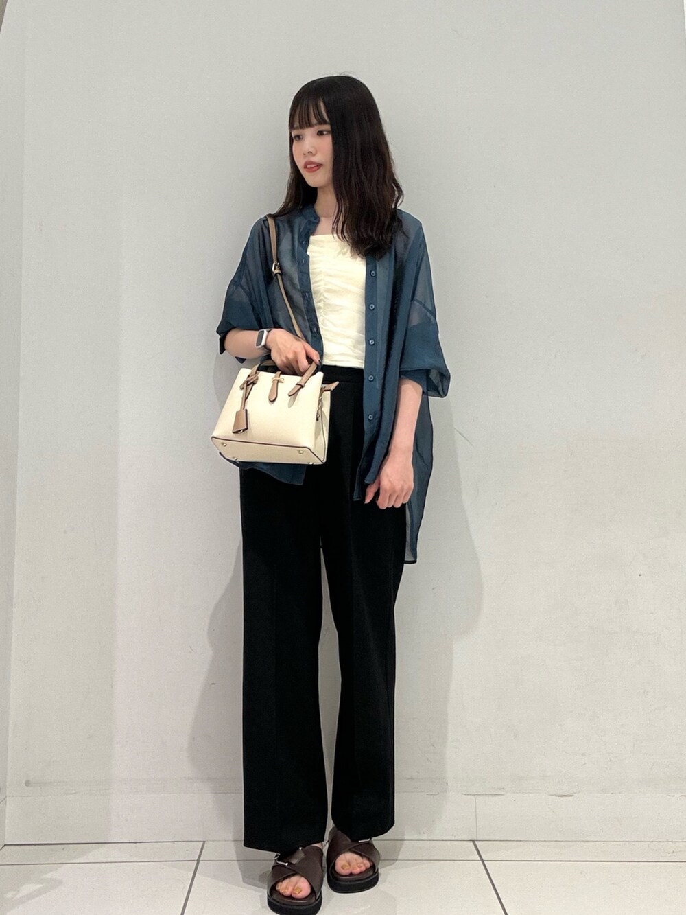 ブラック系のその他パンツ、ブラウン系のサンダル、ホワイト系のハンドバッグを着用したレディースの夏コーディネートの2枚目の写真