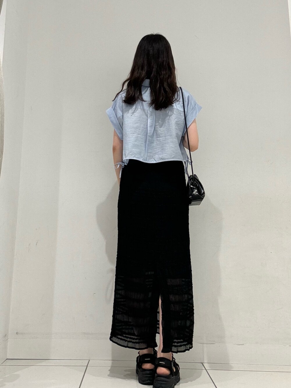 ブルー系のシャツ/ブラウス、ブラック系のスカート、ブラック系のショルダーバッグを着用したレディースの夏コーディネートの3枚目の写真