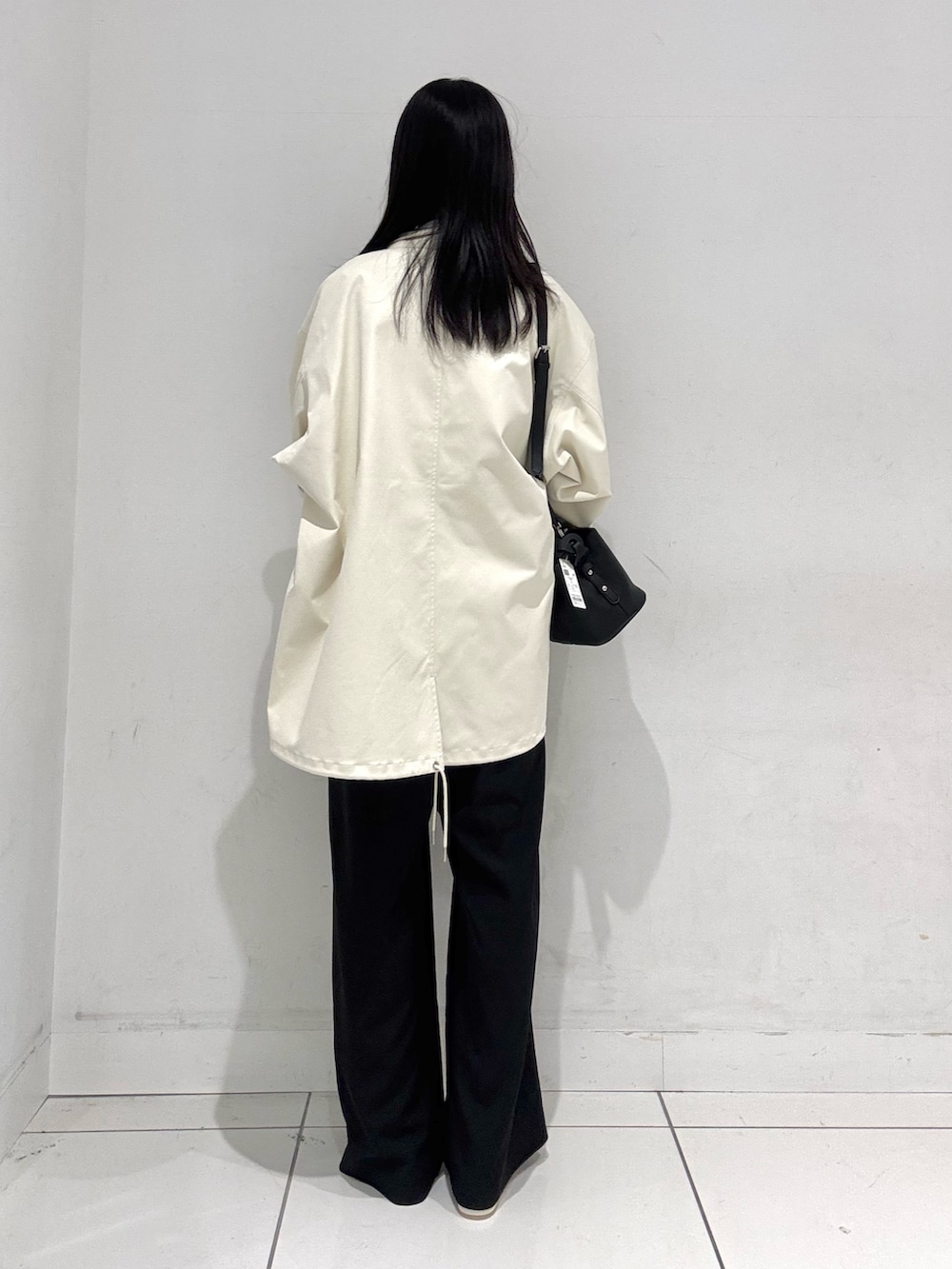 ホワイト系のシャツ/ブラウス、ホワイト系のミリタリージャケット、ブラック系のスラックスを着用したレディースの春コーディネートの3枚目の写真