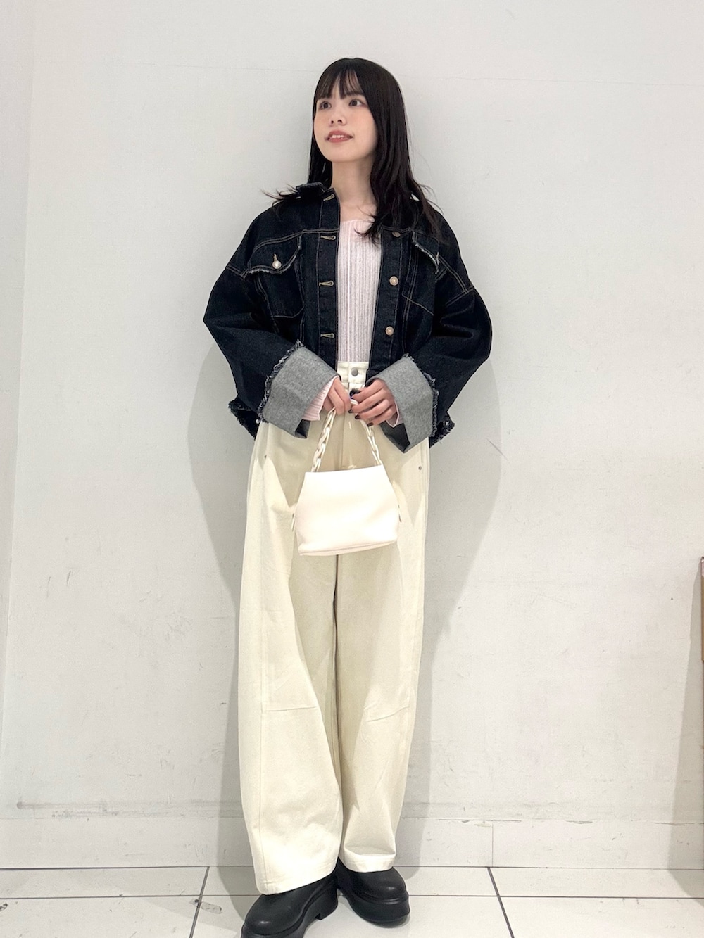 ピンク系のTシャツ/カットソー、ブルー系のデニムジャケット、ホワイト系のショルダーバッグを着用したレディースの冬コーディネートの4枚目の写真