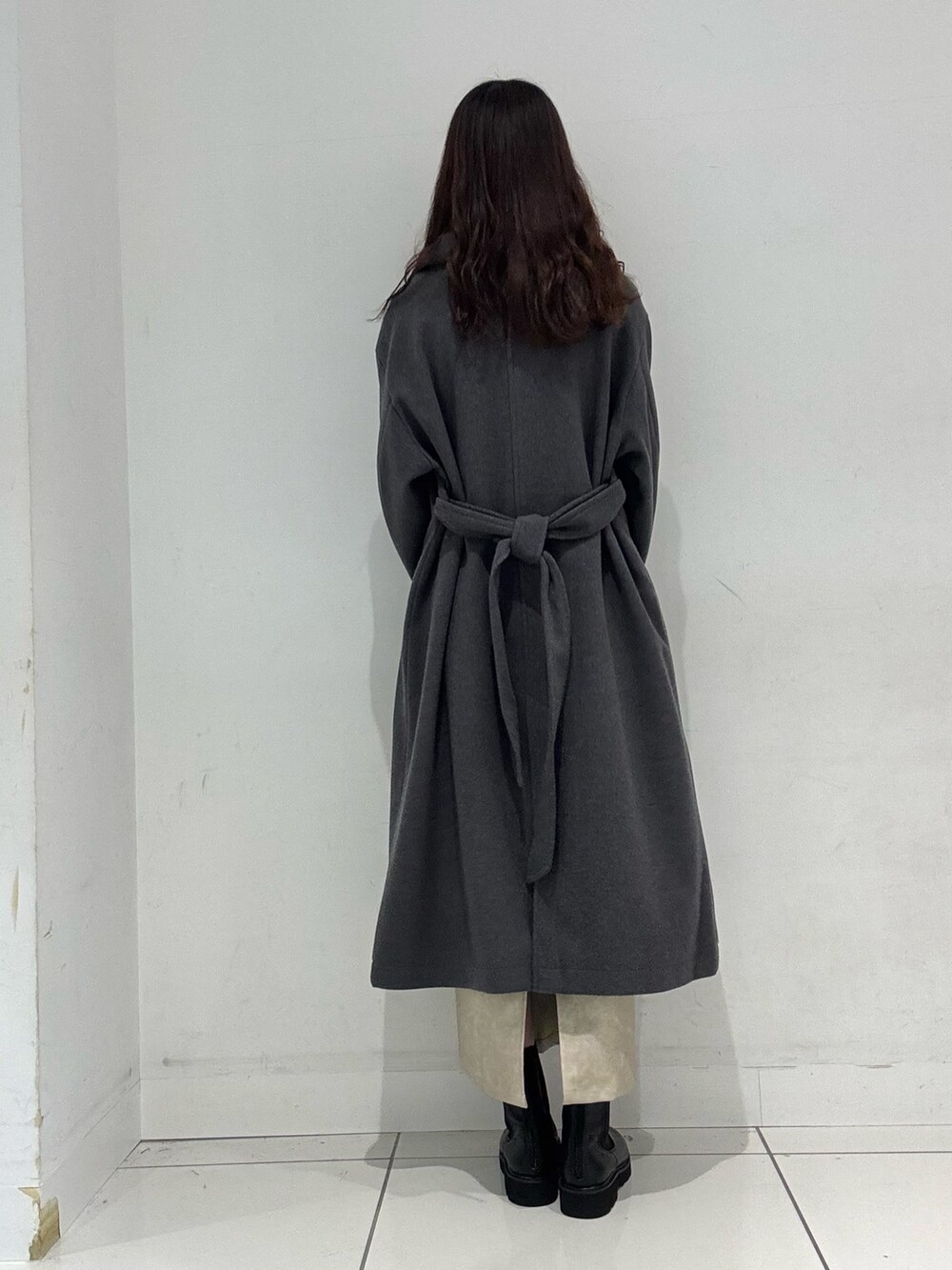 レッド系のニット/セーター、グレー系のその他アウター、ホワイト系のスカートを着用したレディースの冬コーディネートの4枚目の写真