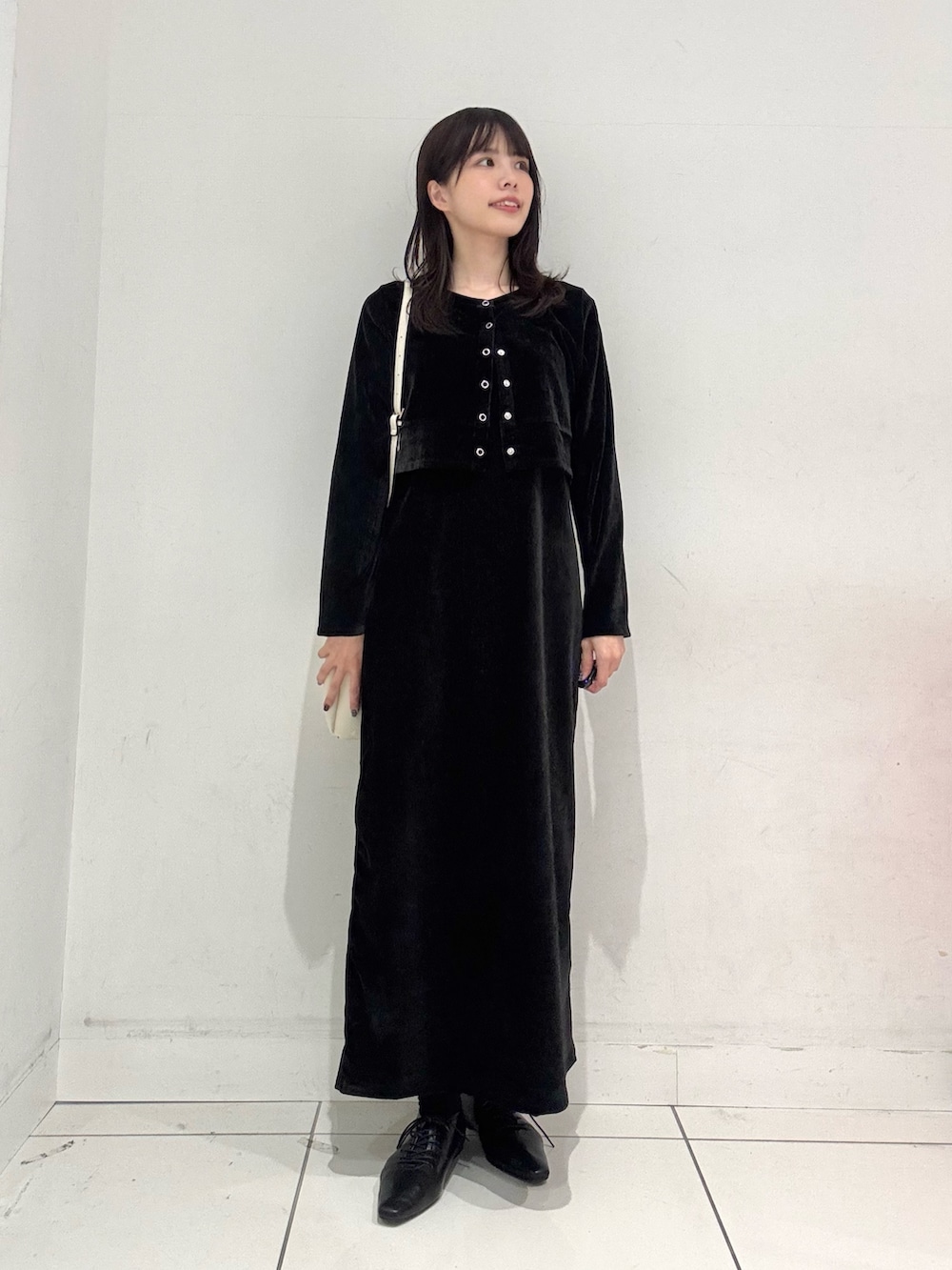 ブラック系のワンピース、ブラック系のその他シューズ、ホワイト系のショルダーバッグを着用したレディースの冬コーディネートの4枚目の写真