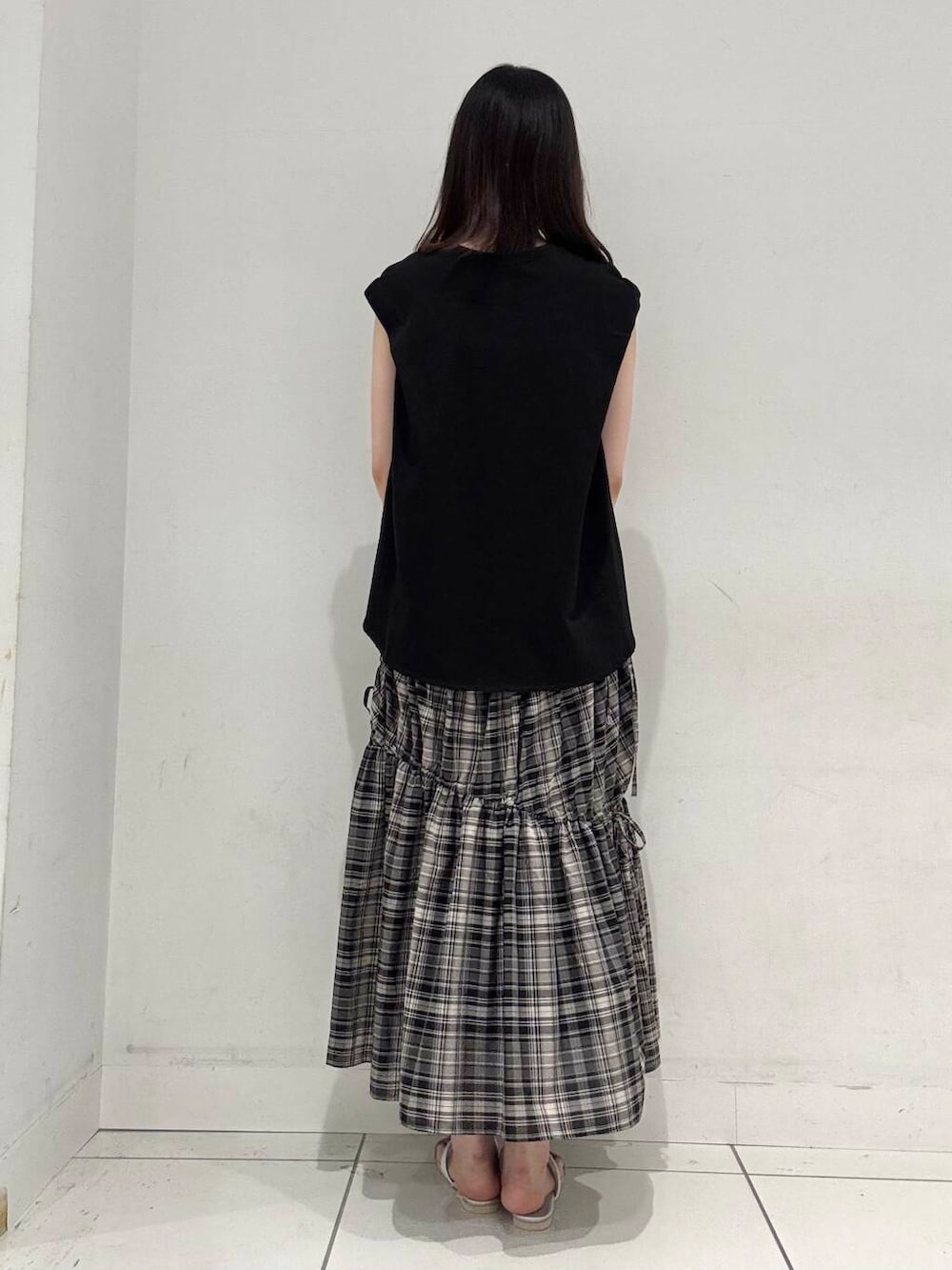 シルバー系のハンドバッグ、シルバー系のサンダル、ブラック系のTシャツ/カットソーを着用したレディースの夏コーディネートの3枚目の写真