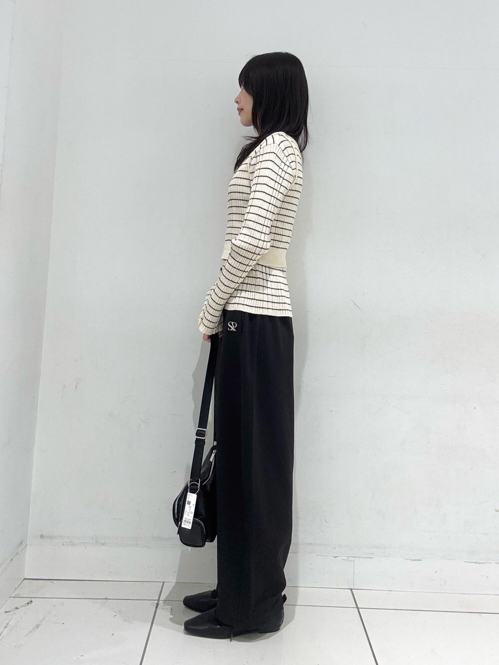 ホワイト系のニット/セーター、ブラック系のその他パンツ、ブラック系のその他シューズを着用したレディースの冬コーディネートの2枚目の写真