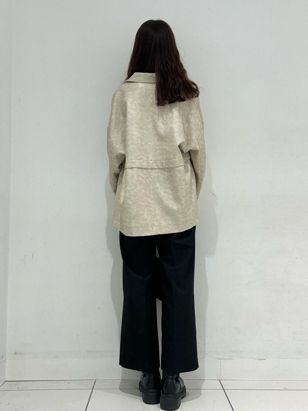 オレンジ系のニット/セーター、ホワイト系のその他アウター、ブラック系のその他パンツを着用したレディースの秋コーディネートの3枚目の写真