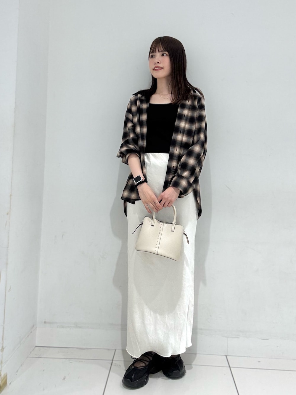 ブラウン系のシャツ/ブラウス、ホワイト系のスカート、ブラック系のスニーカーを着用したレディースの秋コーディネートの4枚目の写真