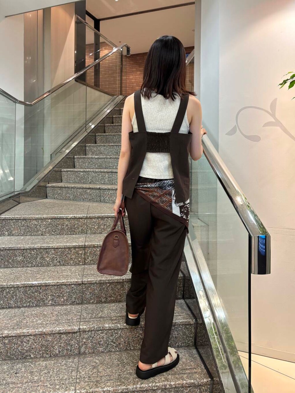 ブラウン系のボストンバッグ、ベージュ系のタンクトップ、ブラウン系のセットアップを着用したレディースの春コーディネートの3枚目の写真