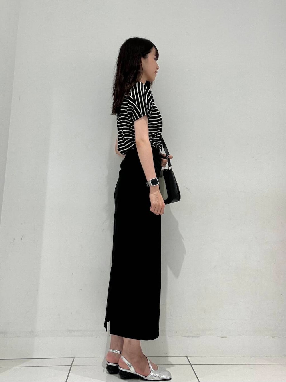 ブラック系のショルダーバッグ、ブラック系のスカート、シルバー系のその他シューズを着用したレディースの夏コーディネートの2枚目の写真