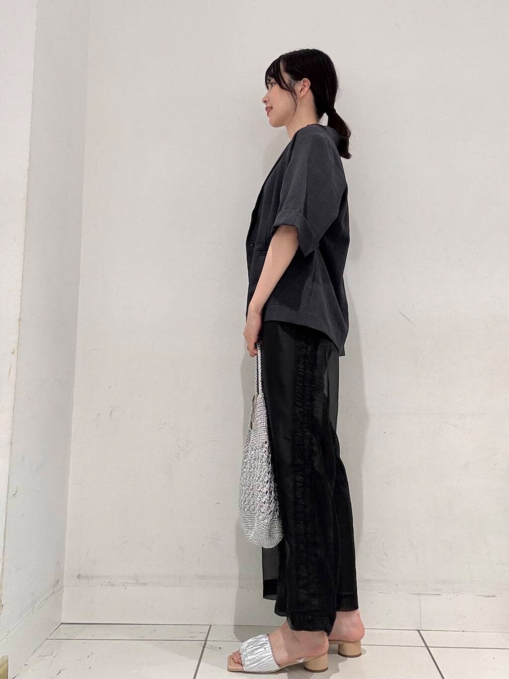 シルバー系のハンドバッグ、シルバー系のサンダル、グレー系のその他アウターを着用したレディースの春コーディネートの2枚目の写真