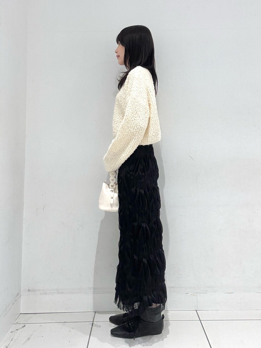 ホワイト系のTシャツ/カットソー、ホワイト系のカーディガン/ボレロ、ブラック系のスカートを着用したレディースの冬コーディネートの2枚目の写真