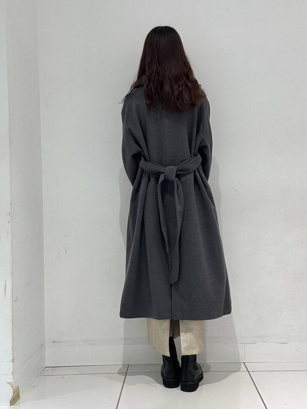 ホワイト系のハンドバッグ、レッド系のニット/セーター、ホワイト系のスカートを着用したレディースの冬コーディネートの4枚目の写真