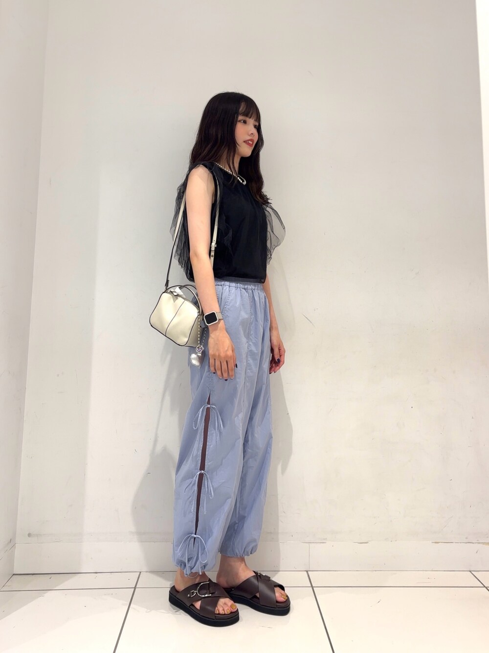 ブラック系のその他トップス、ブラウン系のサンダル、ブルー系のその他パンツを着用したレディースの夏コーディネートの3枚目の写真