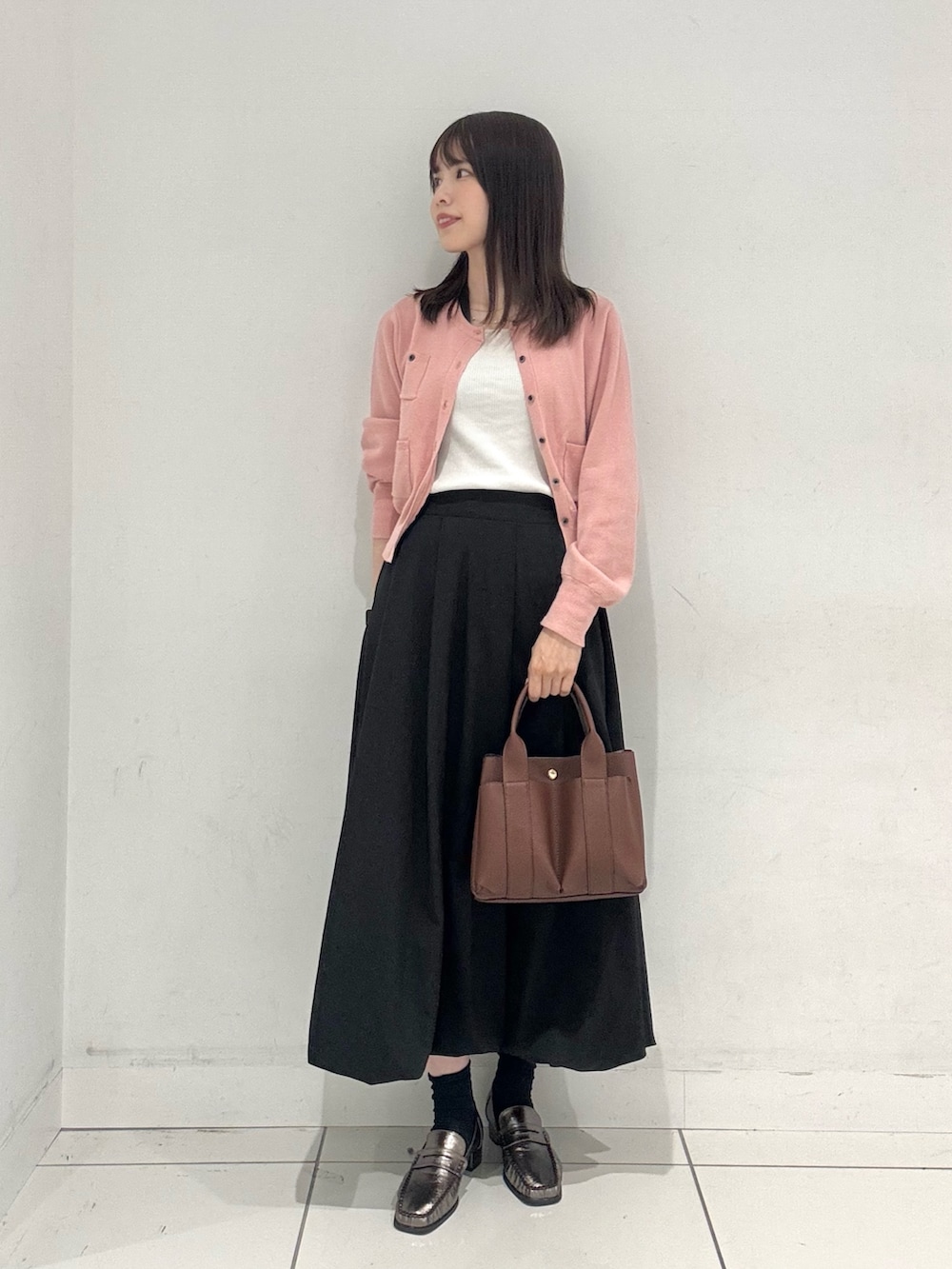 ピンク系のカーディガン/ボレロ、ブラック系のスカート、その他のローファーを着用したレディースの秋コーディネートの4枚目の写真